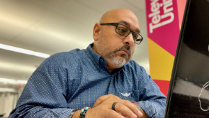 man, office, business, professional, young, smiling, desk, modern, work, corporate, employee, colleague, team, meeting, startup, ambition, career, portrait, confident, happy, workspace, interior, glass walls, city, ai generated